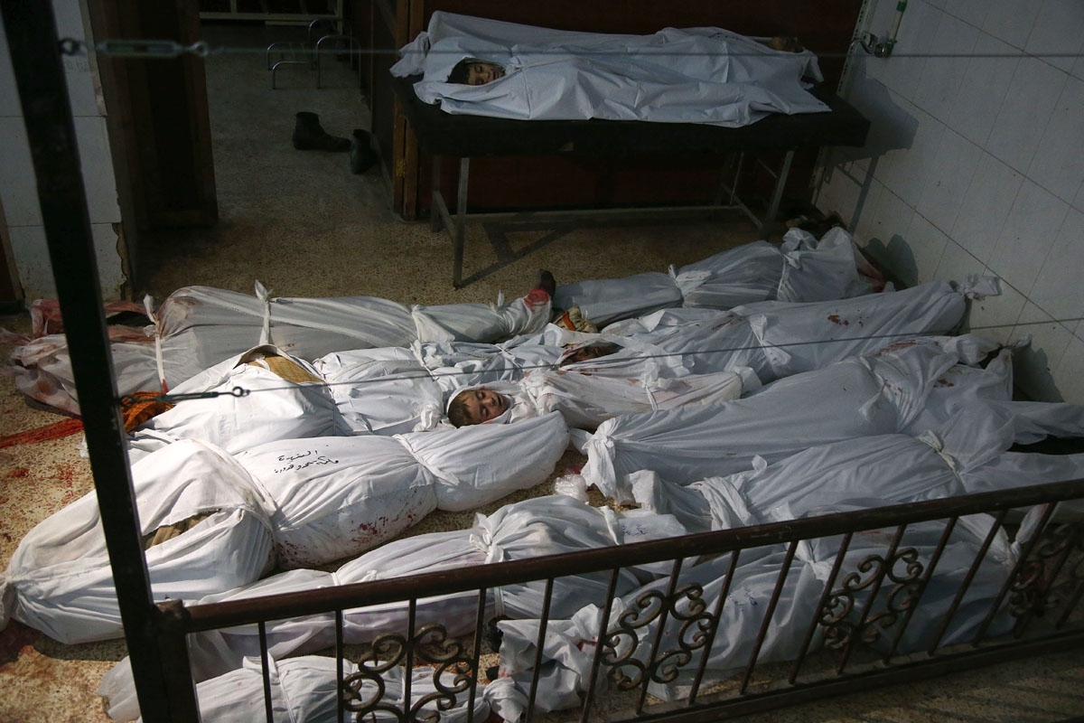 The bodies of civilians who were killed in Syrian army bombardment on the town of Hamouria in the rebel-held enclave of Eastern Ghouta are seen lying on the ground at a make-shift morgue the morning after the attacks on February 20, 2018