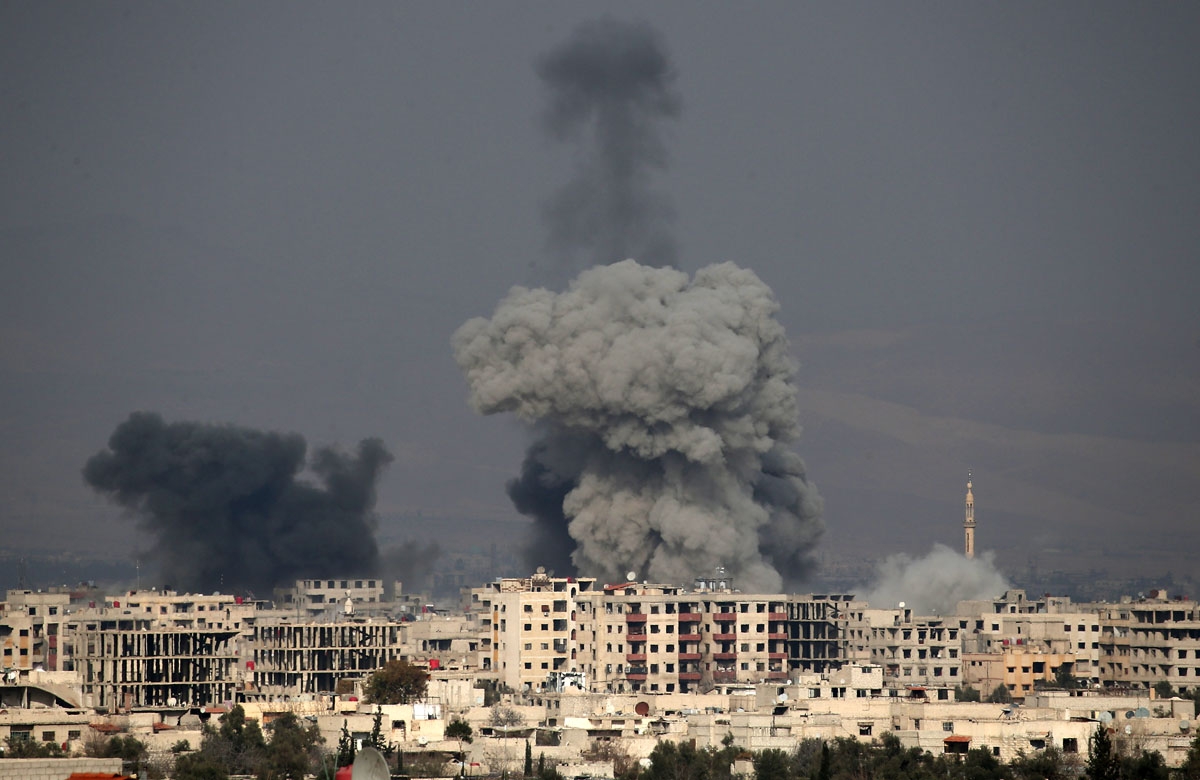 A picture taken on February 20, 2018 shows smoke plumes rising following a reported regime air strike in the rebel-held town of Hamouria, in the besieged Eastern Ghouta region on the outskirts of the capital Damascus.