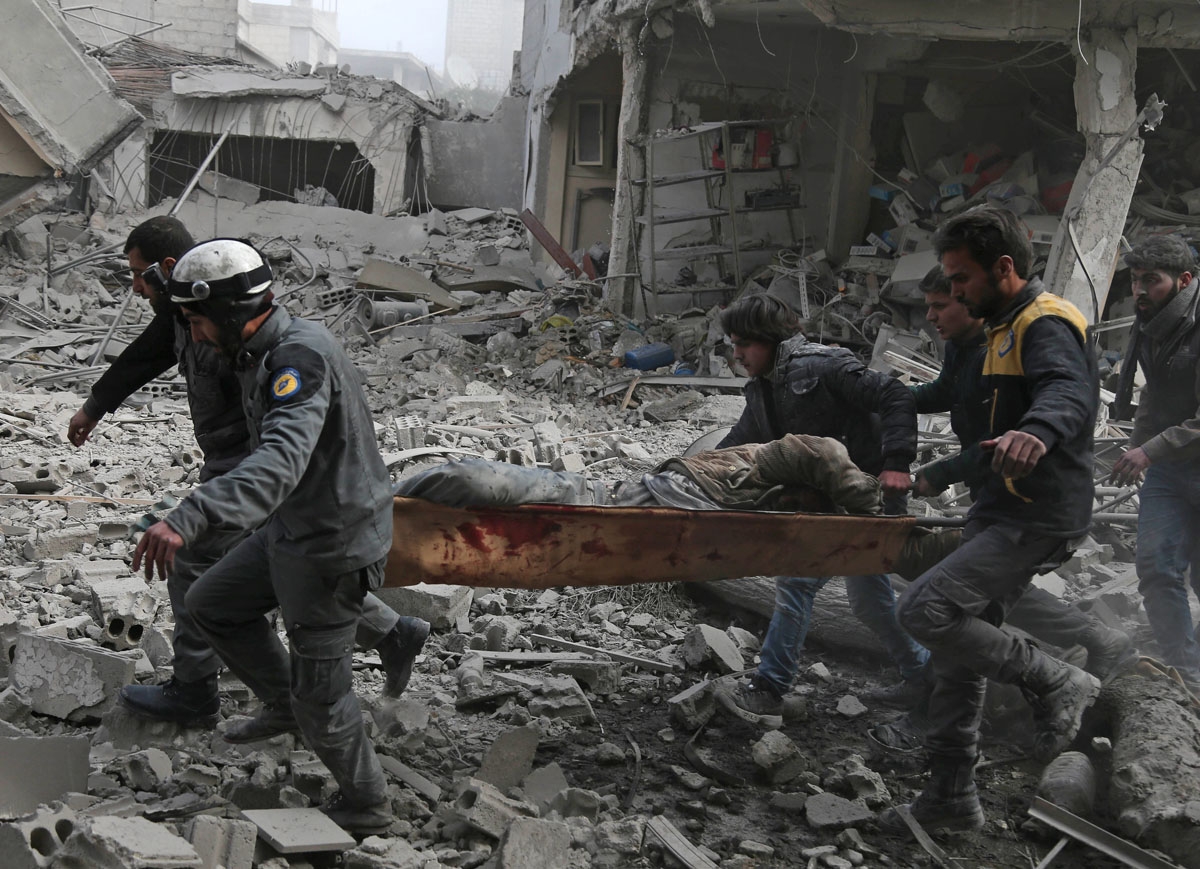 Members of the Syrian civil defence evacuate an injured civilian on a stretcher from an area hit by a reported regime air strike in the rebel-held town of Saqba, in the besieged Eastern Ghouta region on the outskirts of the capital Damascus, on February 2