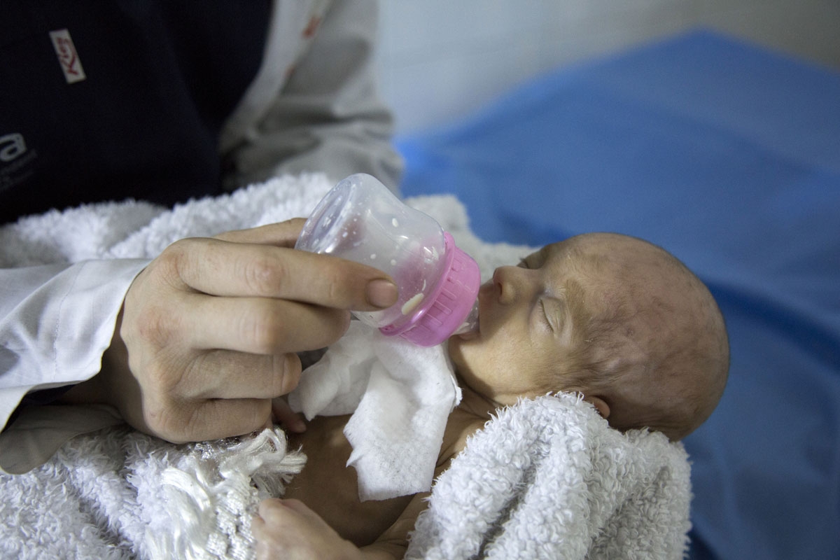A Syrian nurse feeds a newborn who was evacuated by medical staff at a children's hospital into the basement following reported government bombardment which hit within a few hundred metres (yards) of the medical facility a day earlier, in the rebel-held e