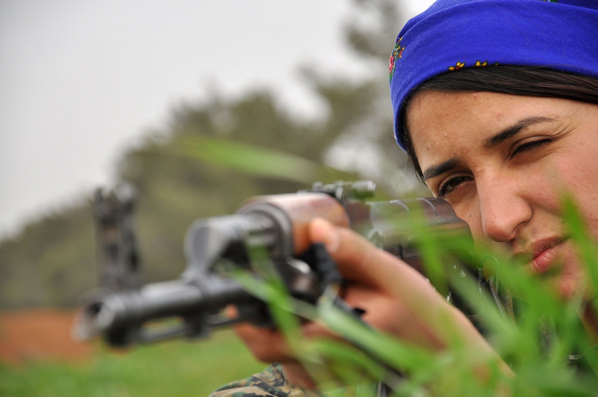 A Kurdish female fighter of the Women's Protection Units (YPJ) aims her weapon at a training camp in al-Qahtaniyah near the Syrian-Turkish border, on February 13, 2015.