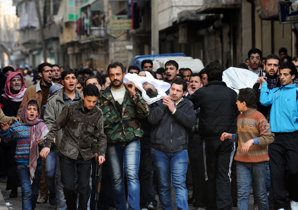 Syrians carry a body of a fighter during a funeral after Friday prayer in the northeastern city of Aleppo on February 15, 2013. Syria's army and rebels were preparing for a major battle for control of strategic airports in Aleppo, the Syrian Observatory f