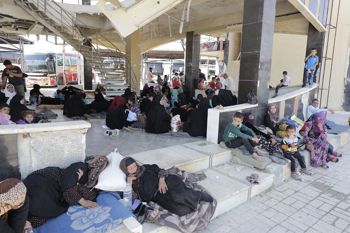 Displaced Syrians who fled with their families Islamic State controlled areas in Raqa, Deir Ezzor and Mayadeen gather at Aleppo's bus station of Ramussa on July 4, 2017.