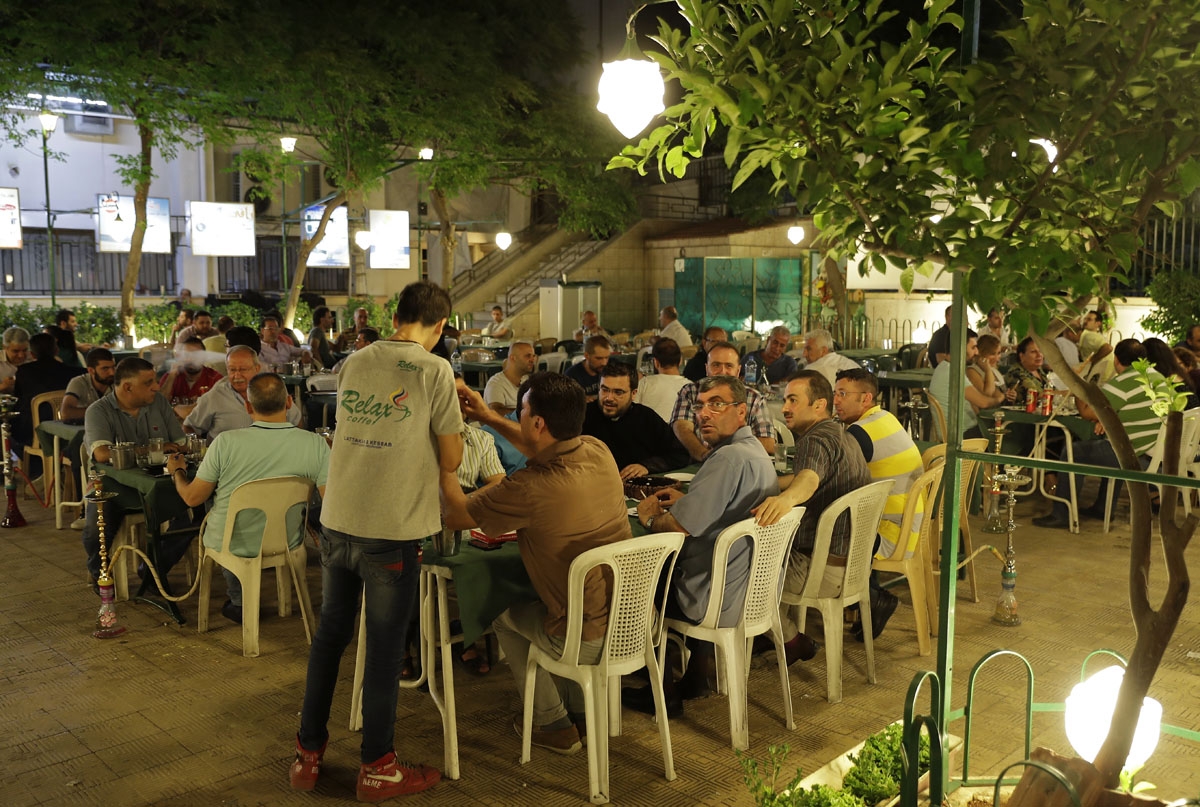 Syrians from Aleppo's Armenian community have dinner at a cafe in the al-Midan neighbourhood of the northern Syrian city on July 5, 2017