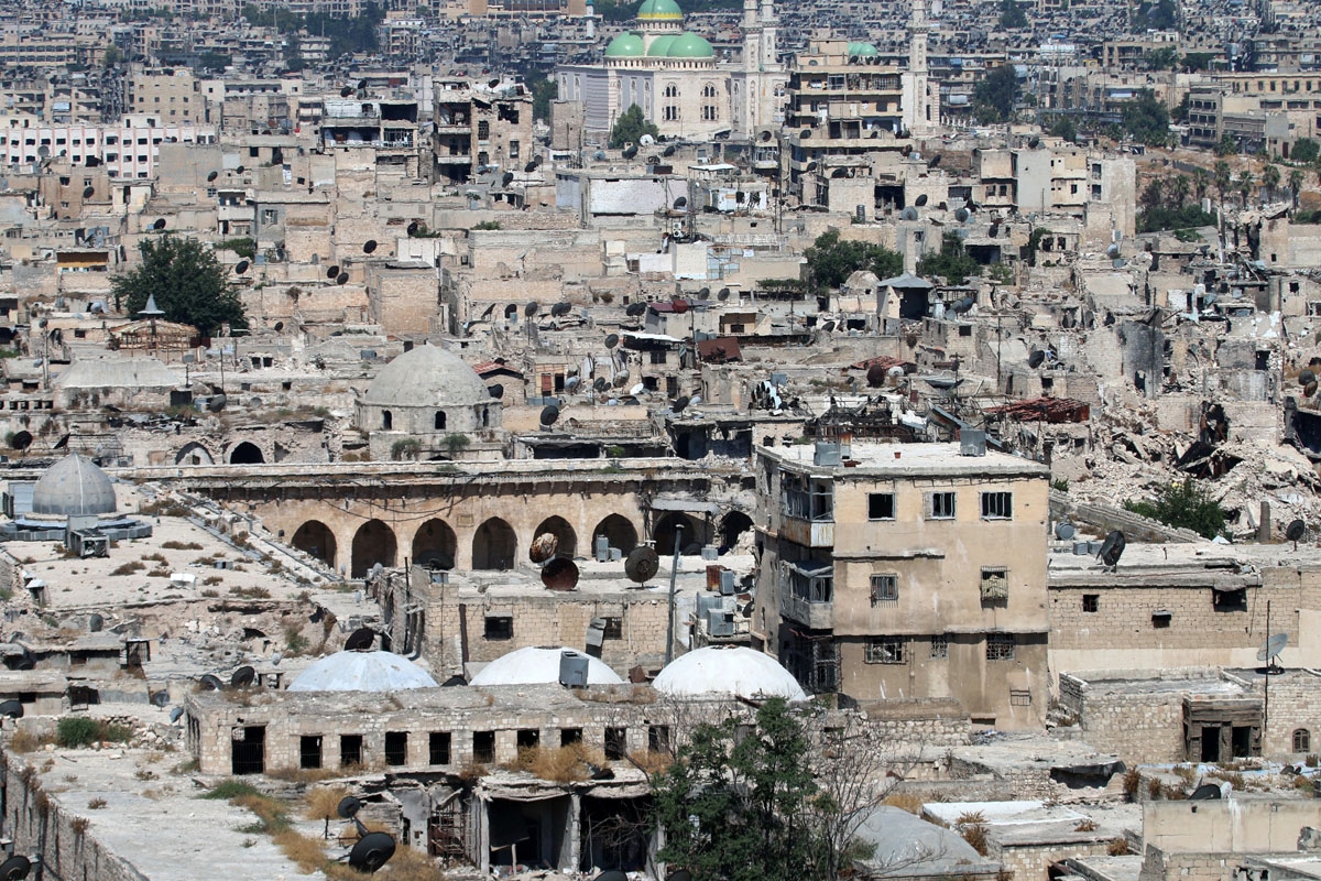 A picture taken on July 3, 2016 from the UNESCO-listed citadel in the government-controlled side of the divided northern Syrian city of Aleppo shows damaged buildings, including the ancient Great Umayyad Mosque (L) at the foot of the medieval fortress.