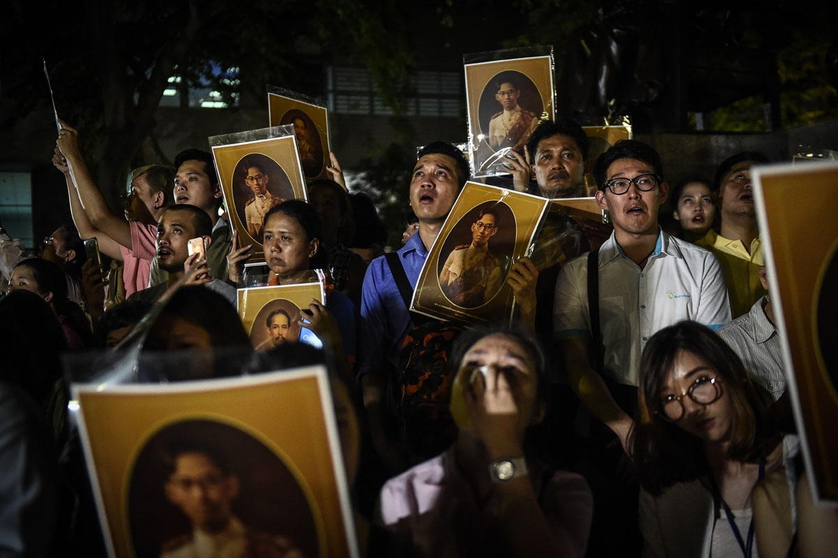 People react to the death of Thailand's King Bhumibol Adulyadej at Siriraj Hospital in Bangkok on October 13, 2016.