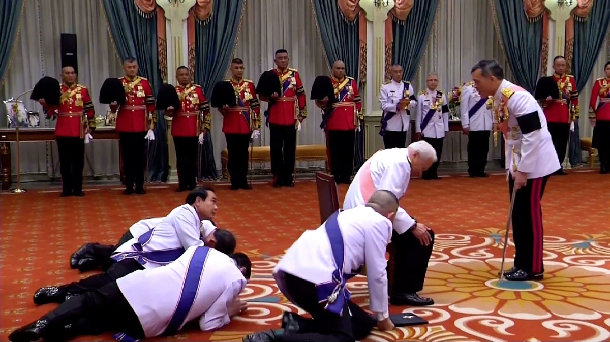 This screengrab from Thai TV Pool taken on December 1, 2016 shows Thai Prime Minister Prayuth Chan-Ocha (middle L) and Privy Council President General Prem Tinsulanonda (C, pink sash) prostrating themselves in front of newly appointed Thai King Maha Vajir