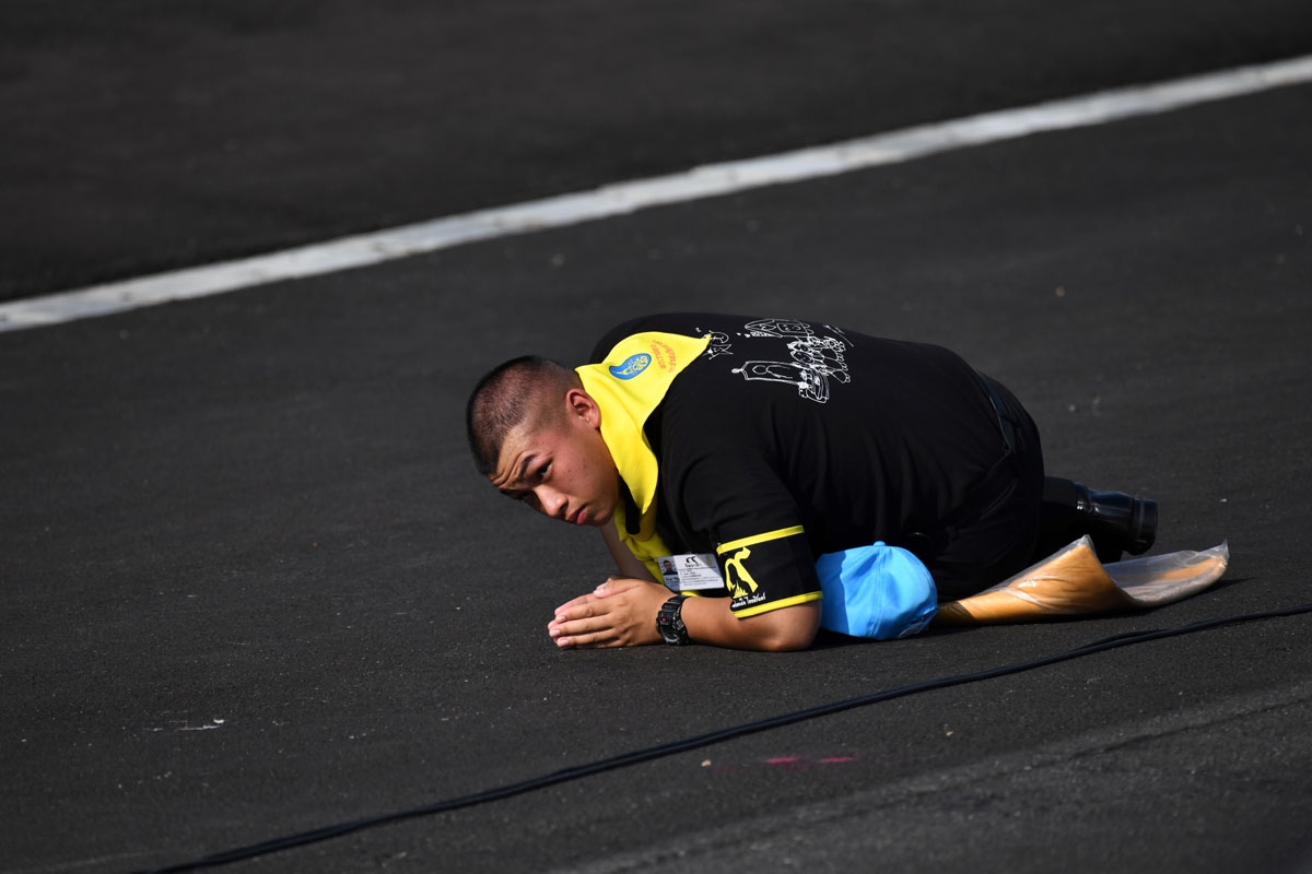 A mourner prostrates as the vehicle carrying Thai King Maha Vajiralongkorn passes before he takes part in a funeral ceremony for his father the late Thai king Bhumibol Adulyadej in Bangkok on October 27, 2017