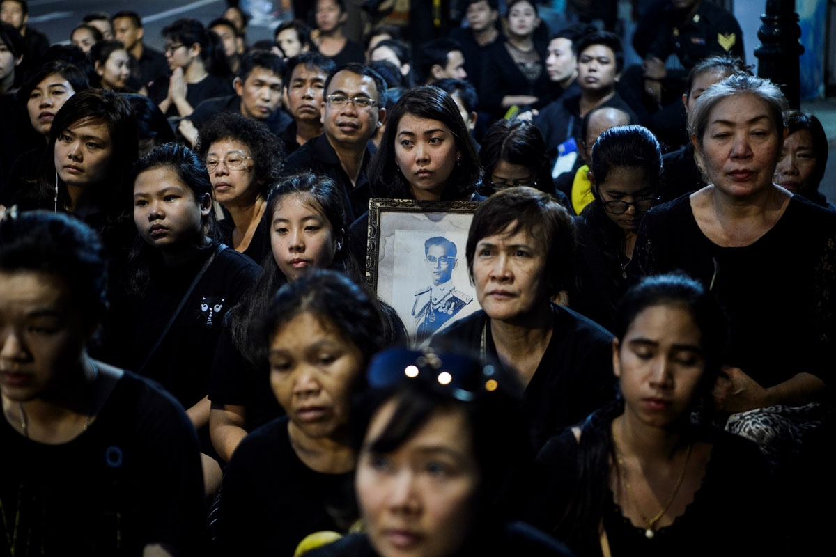 Mourners pray for the late Thai King Bhumibol Adulyadej during the procession transferring the relics and his ashes from the Grand Palace to a local temple in Bangkok on October 29, 2017.