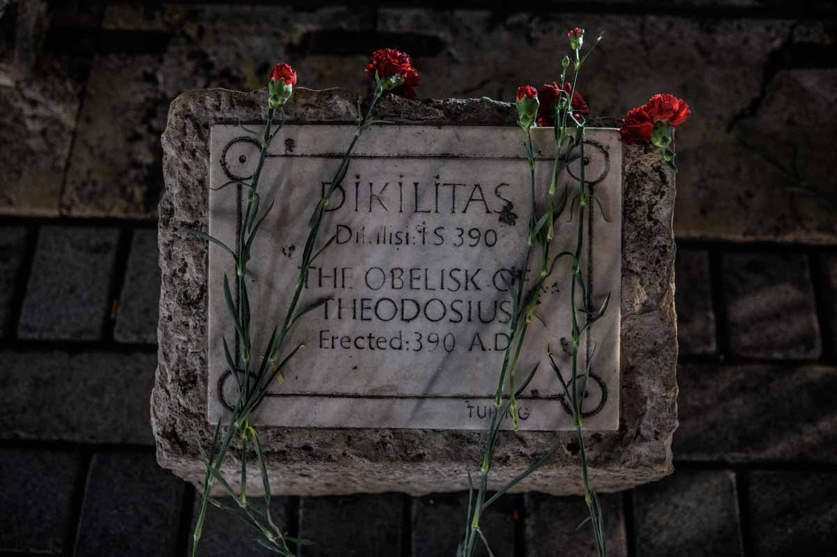 A picture taken on January 13, 2016 shows flowers on a sign stone of The obelist of Theodosius in tribute to the victims of yesterday deadly attack, on January 13, 2016 on the site of the attack in the Istanbul's tourist hub of Sultanahmet.