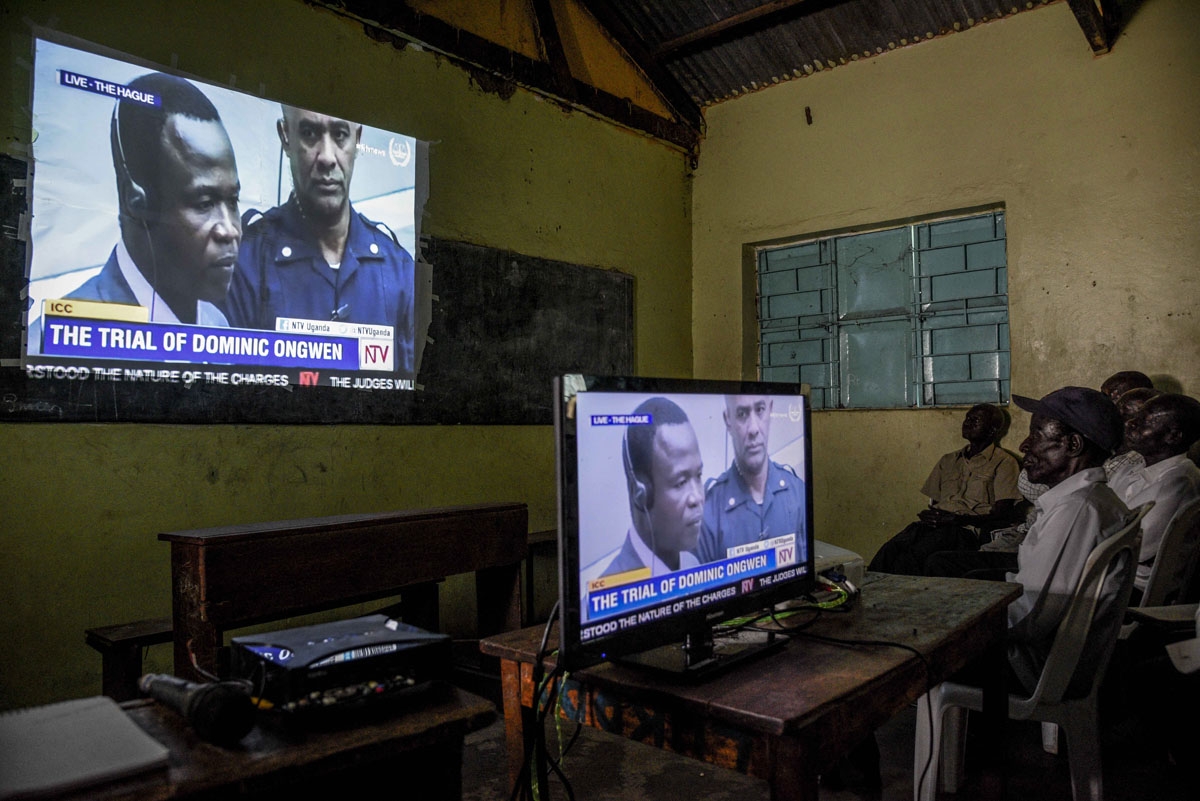 People watch on tv the screening of the start of the ICC (International Criminal Court) trial of former child soldier-turned-warlord Dominic Ongwen in Lukodi, Uganda on December 6, 2016.