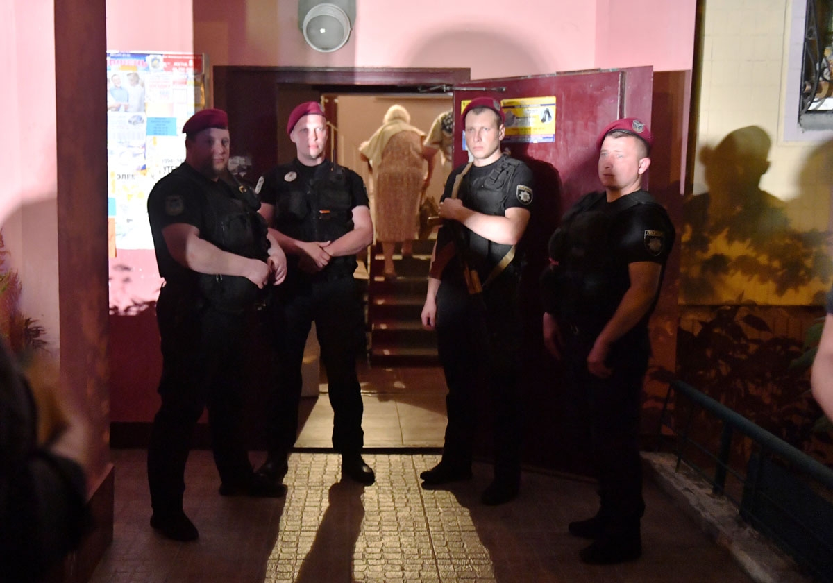 Policemen stand guard at the entrance of the building where journalist Arkadi Babchenko was alleged to have been shot dead in his apartment on May 29, 2018.