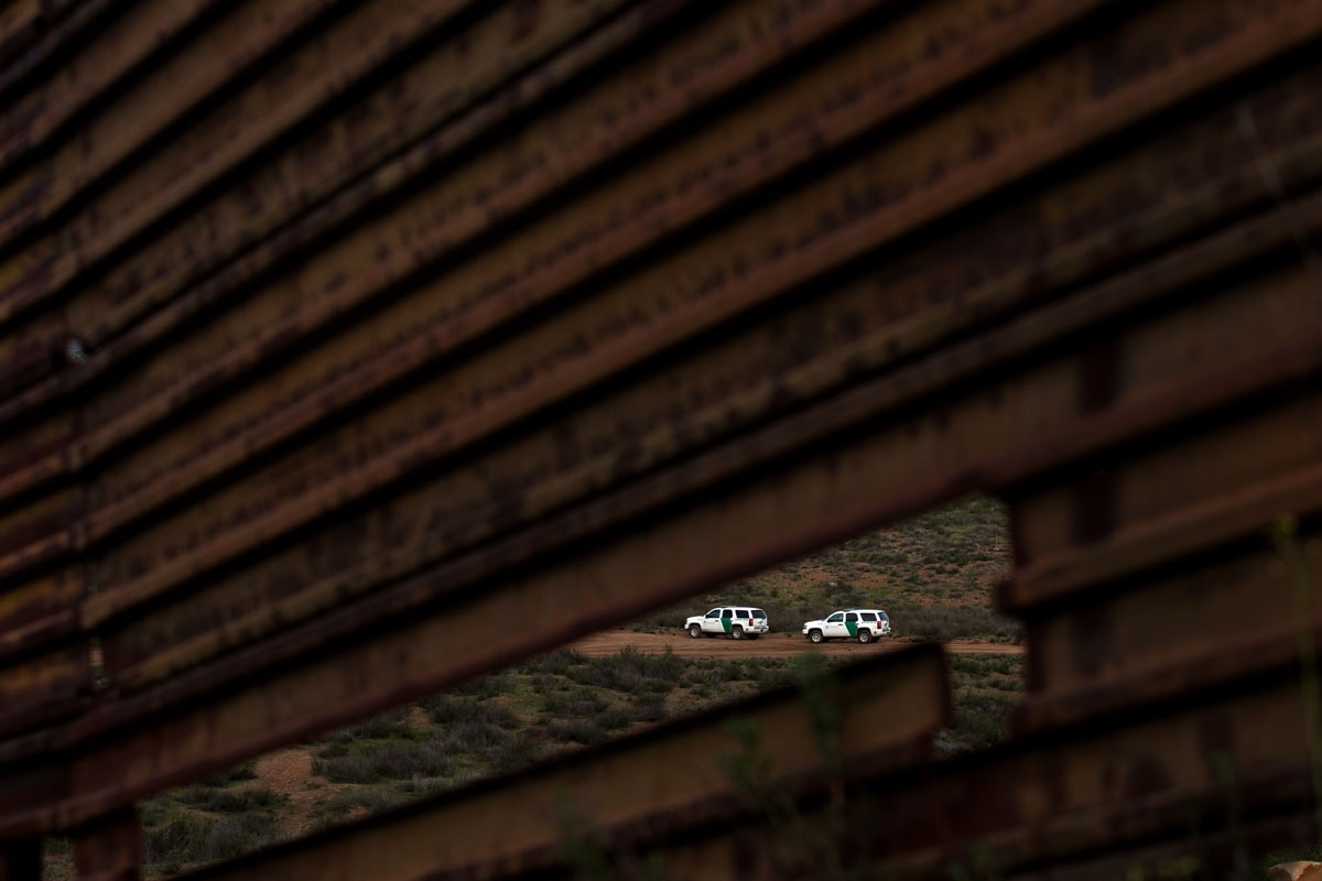 US Border Patrol vehicles are seen through the US/Mexico border fence in Tecate, northwestern Mexico on February 14, 2017.