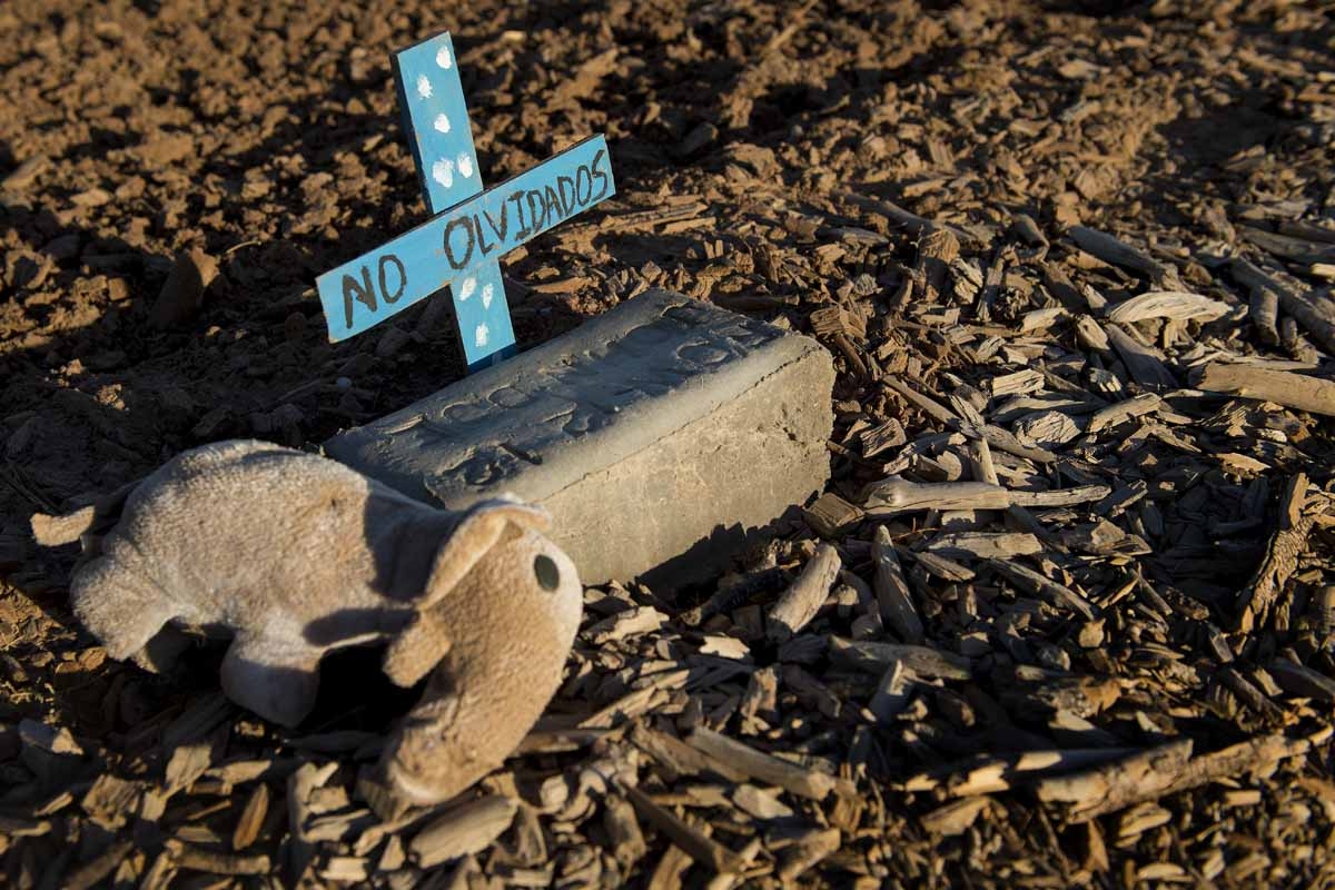 A stuffed animal rests next to a brick inscribed with the words John Doe in an unmarked dirt lot at the end of Terrace Park Cemetery in Holtville, California on February 14, 2017, where the remains of hundreds of unidentified migrants are buried.