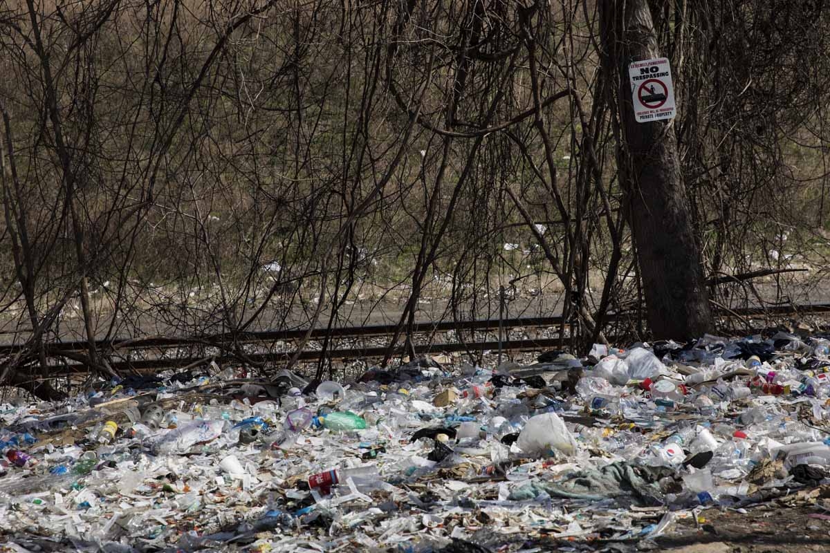 Household trash and empty needle wrapper paper is seen next to rail road tracks near a heroin encampment in the Kensington neighborhood of Philadelphia, Pennsylvania, on April 10, 2017.