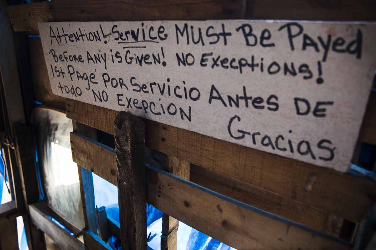 A bi-lingual sign describing terms of service is seen at a heroin encampment in the Kensington neighborhood of Philadelphia, Pennsylvania, on April 10, 2017.