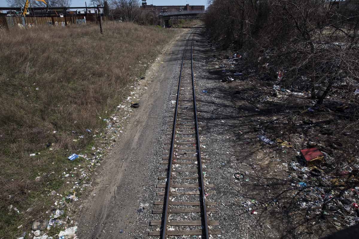 Household trash and empty needle wrapper paper is seen next to rail road tracks near a heroin encampment in the Kensington neighborhood of Philadelphia, Pennsylvania, on April 10, 2017.