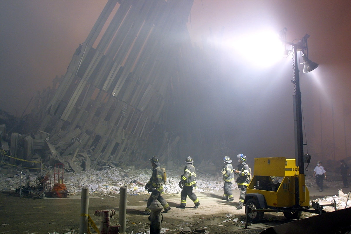 Firefighters make their way through the rubble of the World Trade Center 11 September 2001