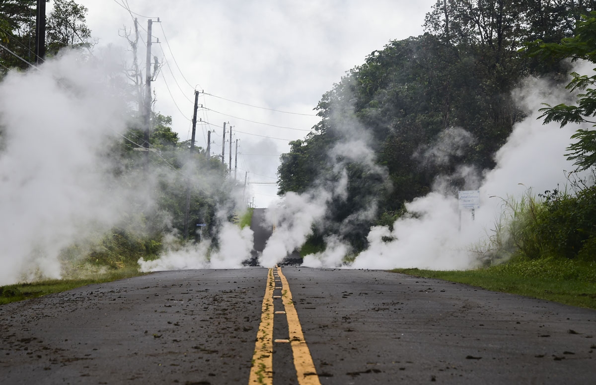 Steam rises from a fissure on a road in Leilani Estates subdivision on Hawaii's Big Island on May 4, 2018.