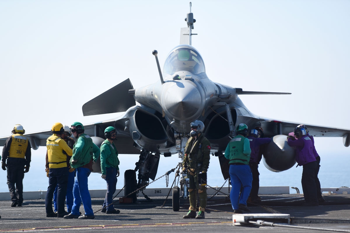 French Navy personel gather around a French pilot and its Rafale jet after it landed the deck of the USS George H.W. Bush aircraft carrier on May 11, 2018 in the Atlantic Ocean.