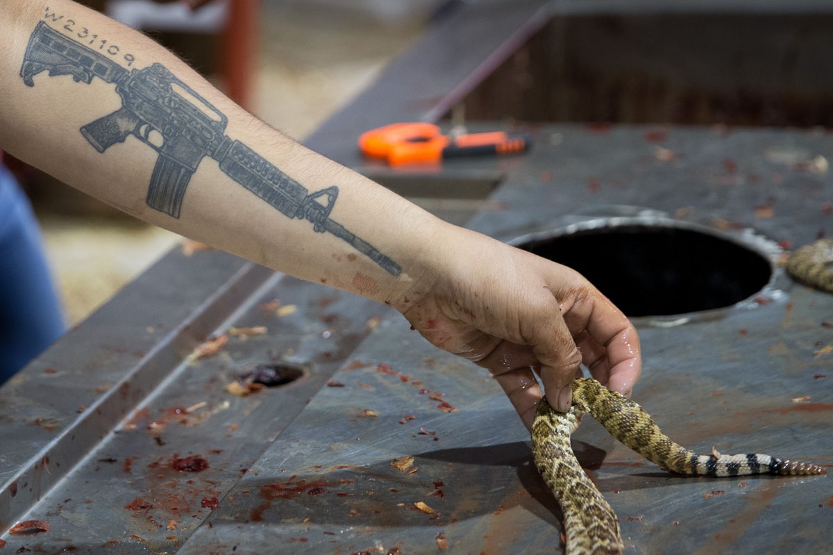 Albert Rodriquez skins a rattlesnake at a demonstration area during the Sweetwater Rattlesnake Roundup at Nolan County Coliseum on March 11, 2018 in Sweetwater, Texas. / AFP PHOTO / Loren Elliott