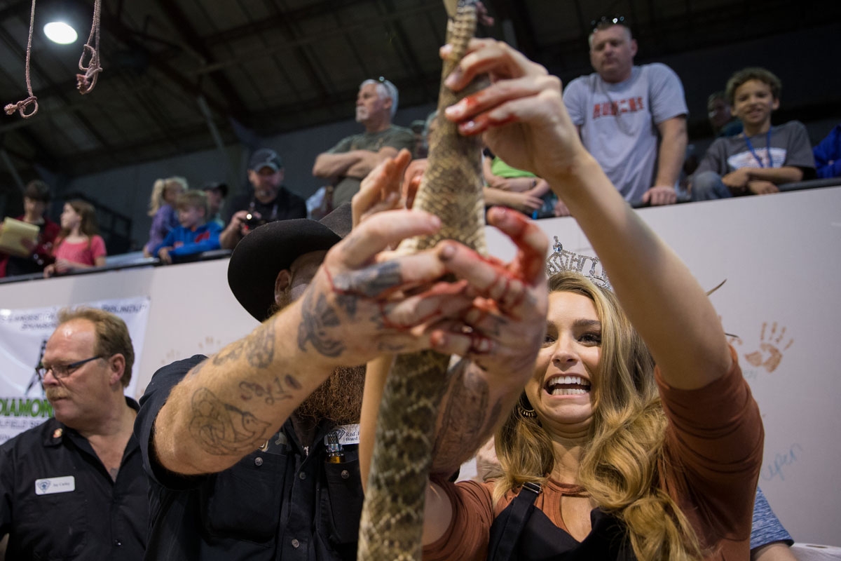 Miss Texas Margana Wood skins a rattlesnake under the guidance of Red Hurd II during the Sweetwater Rattlesnake Roundup at Nolan County Coliseum on March 10, 2018 in Sweetwater, Texas.