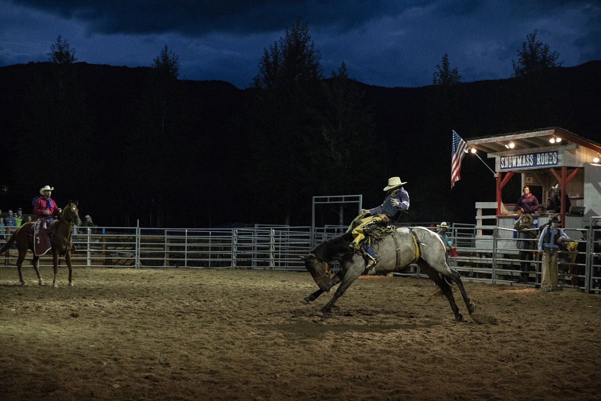 A cowboy rides a bucking bronco at the Snowmass Rodeo on August 22, 2018, in Snowmass, Colorado.