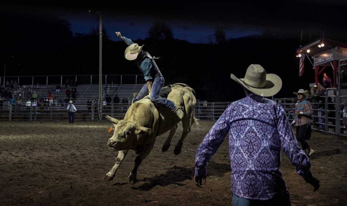 A cowboy rides a bull at the Snowmass Rodeo on August 22, 2018, in Snowmass, Colorado.
