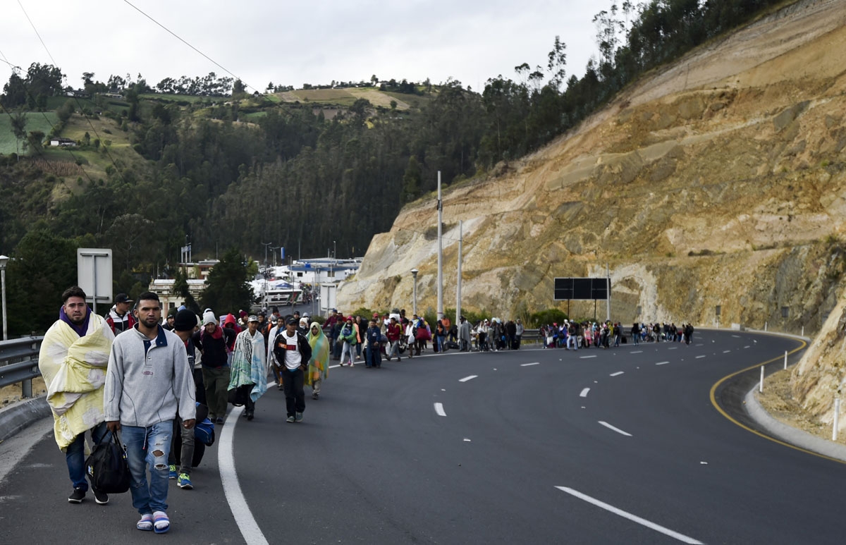 Venezuelans heading to Peru walk along the Panamerican highway in Tulcan, Ecuador, after crossing from Colombia, on August 21, 2018.