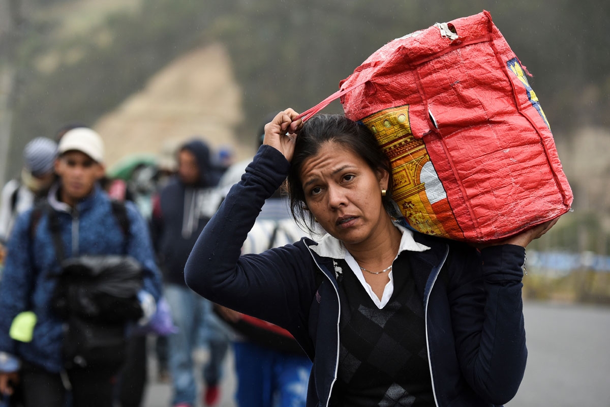 A Venezuelan migrant woman heading to Peru walks along the Panamerican highway in Tulcan, Ecuador, after crossing from Colombia, on August 21, 2018.