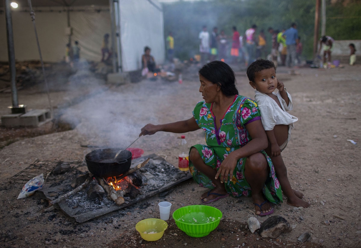 Members of the Warao tribe, Venezuela's second-largest indigenous group, prepare food at the Janokoida shelter where they have been taking refuge in the border city of Pacaraima, Roraima State, Brazil, on August 21, 2018.