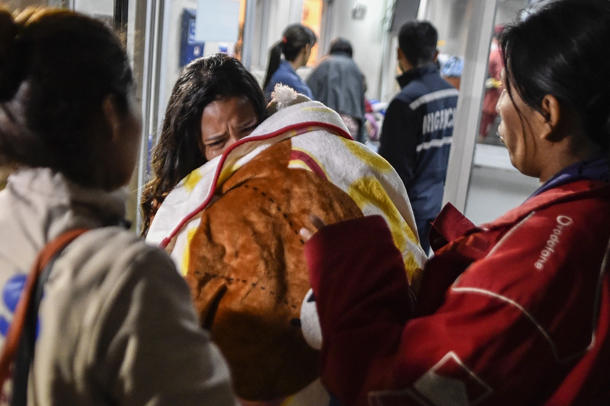 Eliana Balza, 19, (C) cries as she holds her baby Tiago, after the Ecuadoran authorities banned her from entering the country, at the Ecuadoran migrations office at the Rumichaca International Bridge, on August 24, 2018.