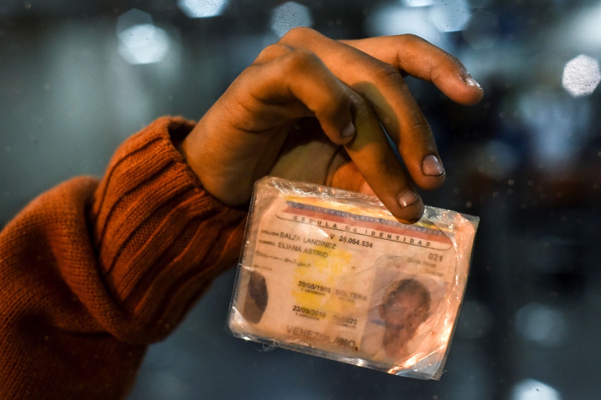 Eliana Balza, 19, shows her damaged Venezuelan identity card, after the Ecuadoran authorities banned her from entering the country, at the Ecuadoran migrations office at the Rumichaca International Bridge on August 24, 2018.