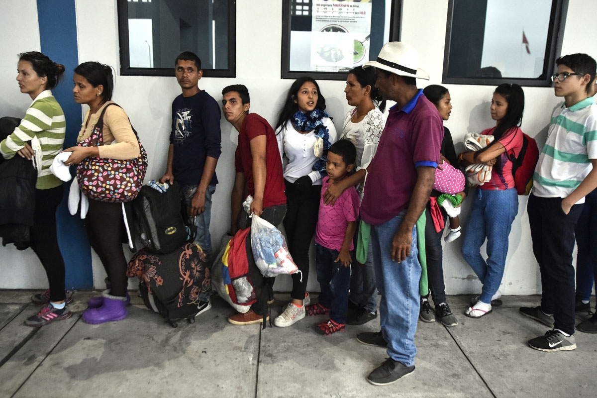 Members of the Mendoza Landinez family wait in line to apply for refugee status, outside the Peruvian immigration offices, in Tumbes, Peru, on August 25, 2018.