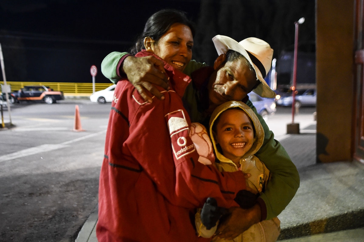 Joel Mendoza (C), 51, embraces his partner Edicth Landinez (L), 34, and her son Sebastian, 6, outside the Colombian migrations office at the Rumichaca International Bridge, in the border between Ipiales, Colombia, and Tulcan, Ecuador, on August 23, 2018,