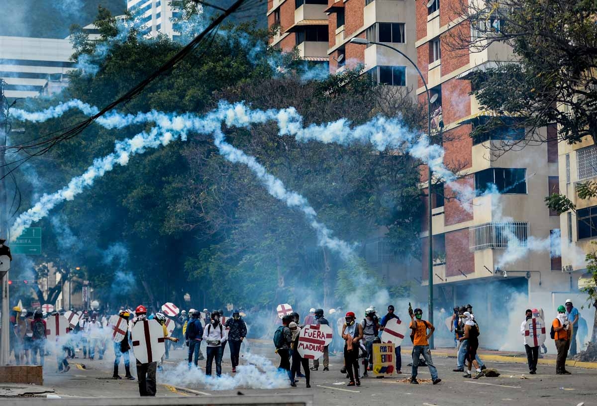 Opposition demonstrators and riot police clash during a protest against Venezuelan President Nicolas Maduro, in Caracas on May 3, 2017. Venezuelan police fired tear gas and hooded protesters hurled Molotov cocktails as thousands rallied Wednesday in anger