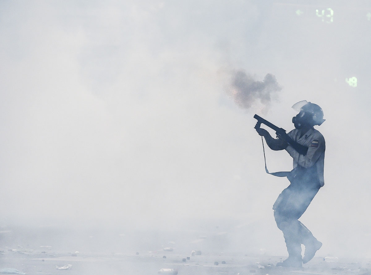 A riot policeman fires a tear gas grenade at opposition activists during a protest against President Nicolas Maduro, in Caracas on May 8, 2017.