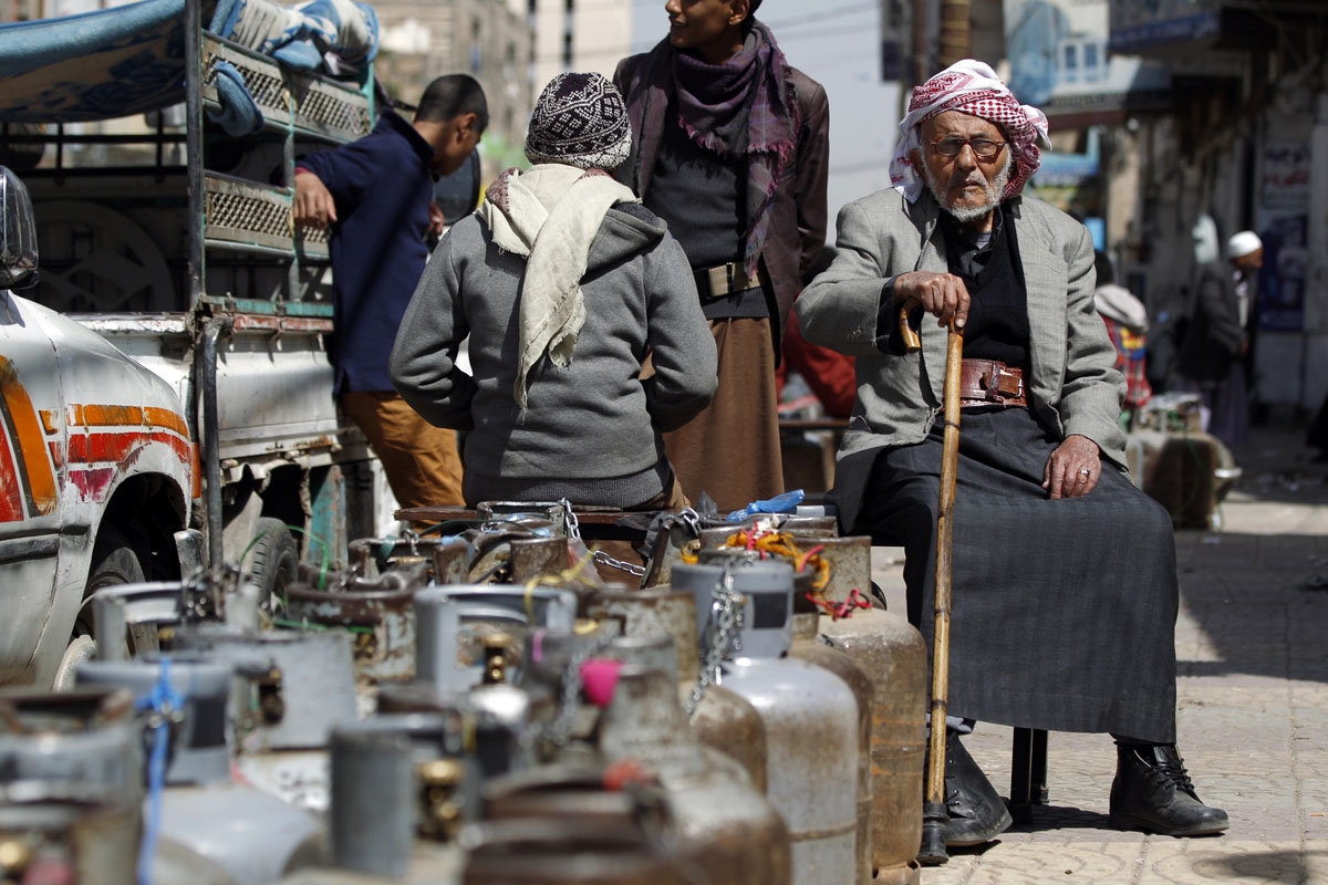 Yemenis wait next to empty gas cylinders for gas supplies amid increasing shortages in the Yemeni capital Sanaa, on March 5, 2018