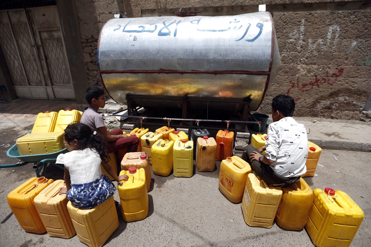 Yemeni children fill jerrycans with safe drinking water from a donated water-tank in the capital Sanaa on July 2, 2017.