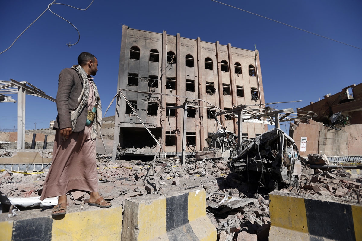 A man stands next to the Yemeni criminal investigations unit in the capital Sanaa on February 5, 2018, a day after the building was hit in an air raid.