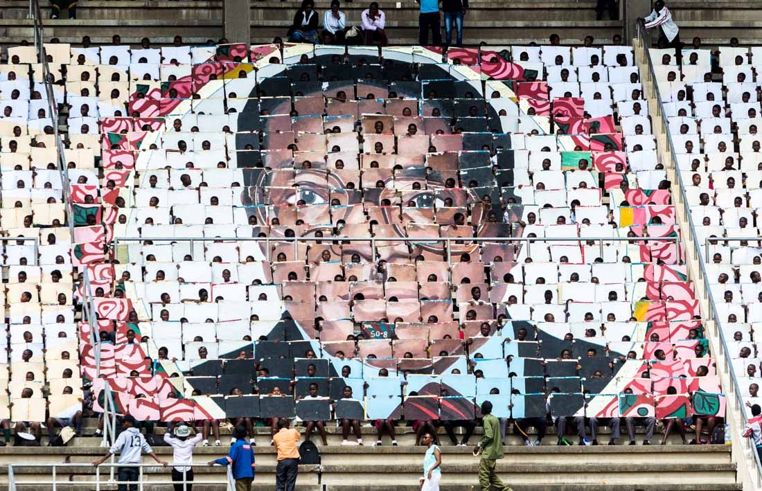 School children hold an image of Zimbabwe's President Robert Mugabe during the country's 37th Independence Day celebrations at the National Sports Stadium in Harare April 18, 2017.