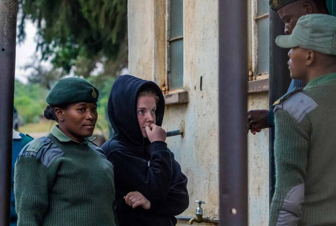US journalist Martha O'Donovan (C), who was arrested on charges of insulting Zimbabwe's president and attempting to subvert the country's regime, talks with Zimbabwe Correctional Services officers as she leaves Chikurubi Maximum Prison near Harare, after