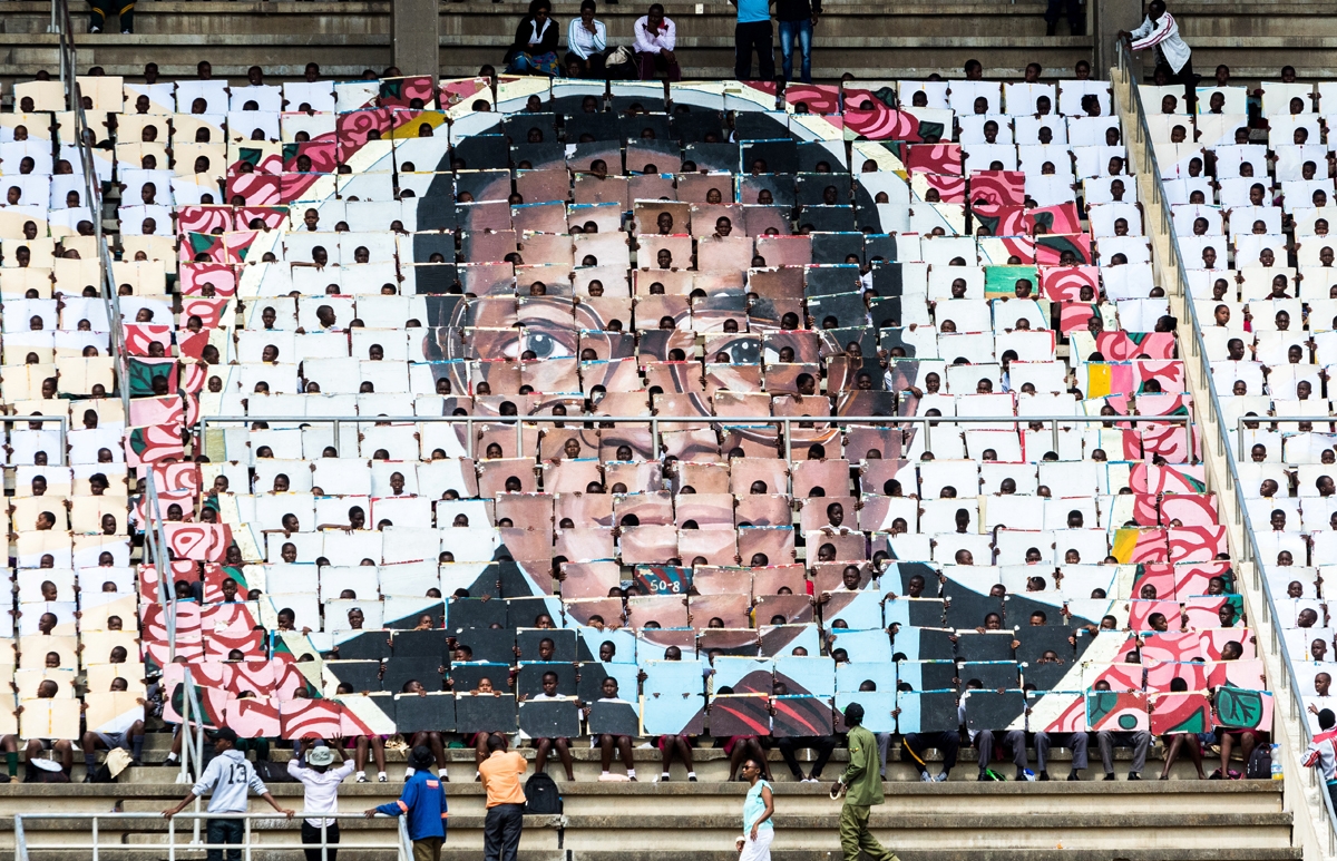School children hold an image of Zimbabwe's President Robert Mugabe during the country's 37th Independence Day celebrations at the National Sports Stadium in Harare April 18, 2017.