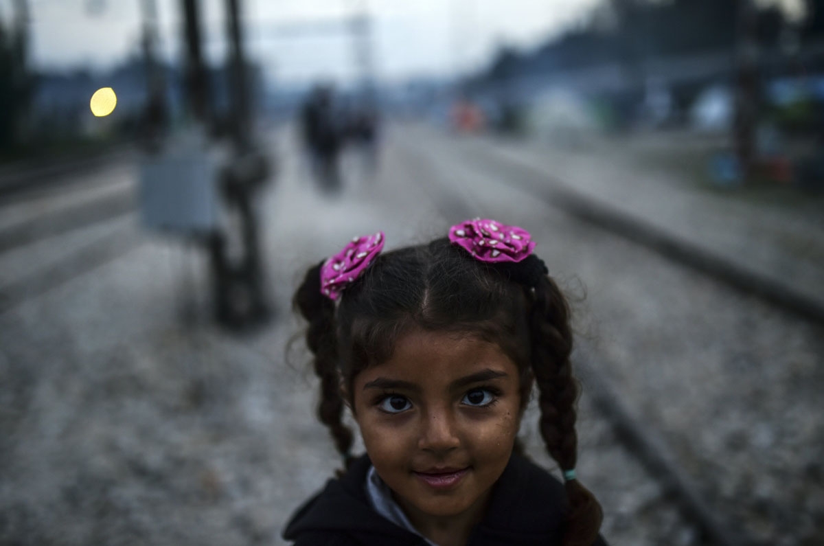 A Syrian refugee girl stands on the rail way at the makeshift camp along the Greek-Macedonian border, near the Greek village of Idomeni on April 1, 2016, where thousands of refugees and migrants are stranded by the Balkan border blockade.