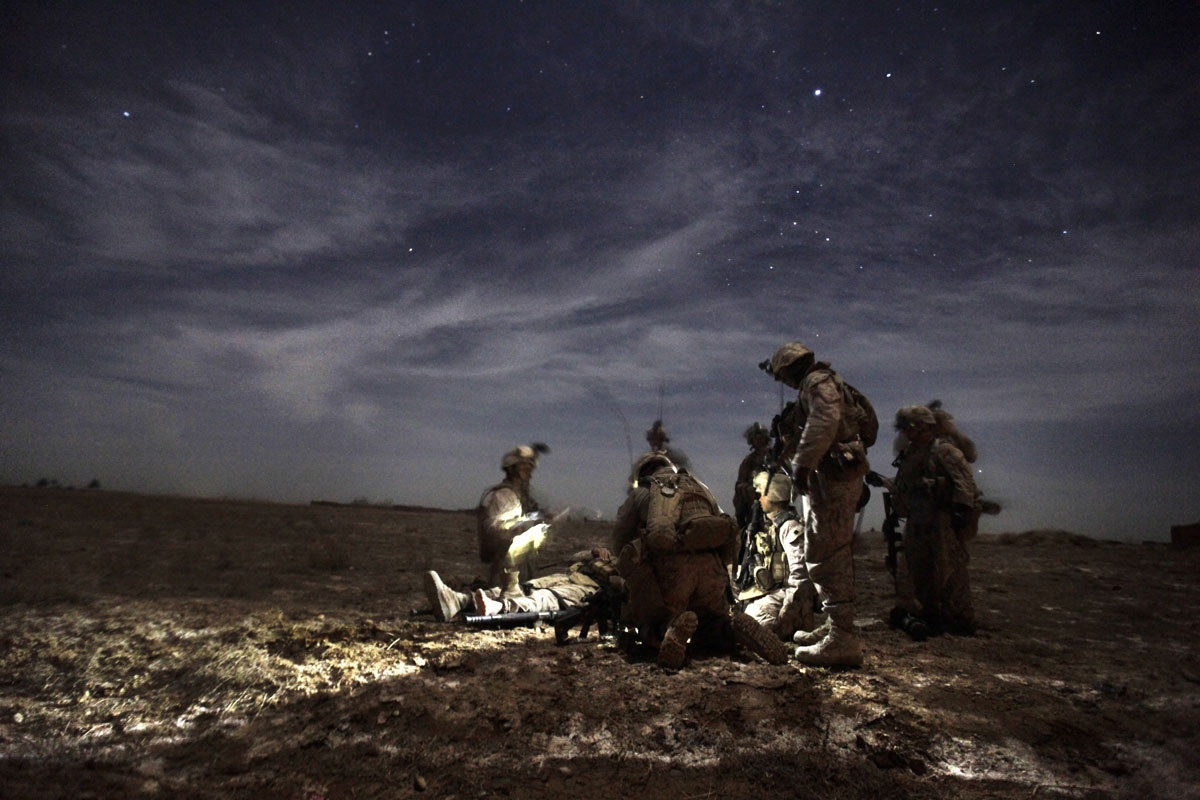 US Marines with 1/3 Charlie Company treat Lance Corporal Kris Mottley (21) from Pensylvania as they wait for a MEDEVAC helicopter, after their MRAP vehicle was hit by an Improvised Explosive Device (IED) in Trikh Nawar on the north-eastern outskirts of Ma