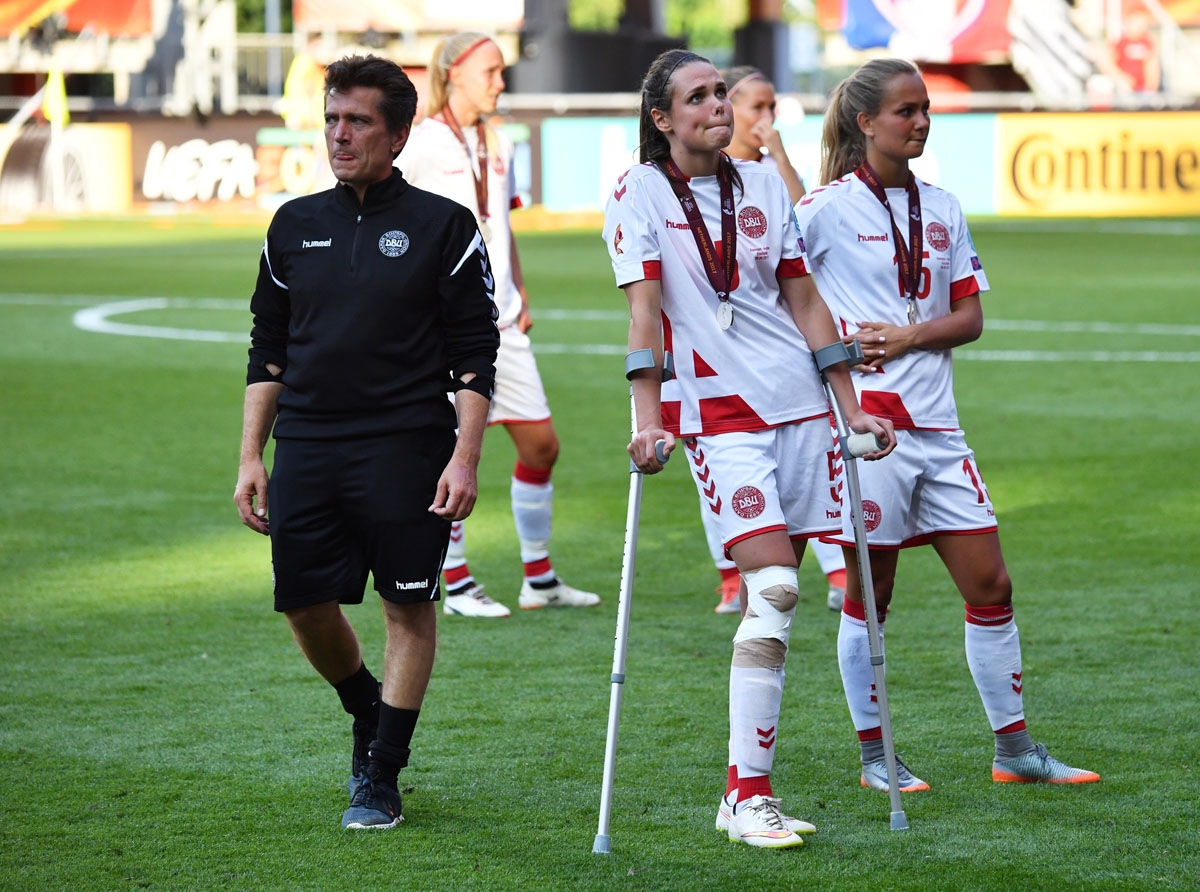 Denmark's head coach Nils Nielsen (L) and his team players react at the end of the UEFA Womenâs Euro 2017 football tournament final match between Netherlands and Denmark at Fc Twente Stadium in Enschede on August 6, 2017
