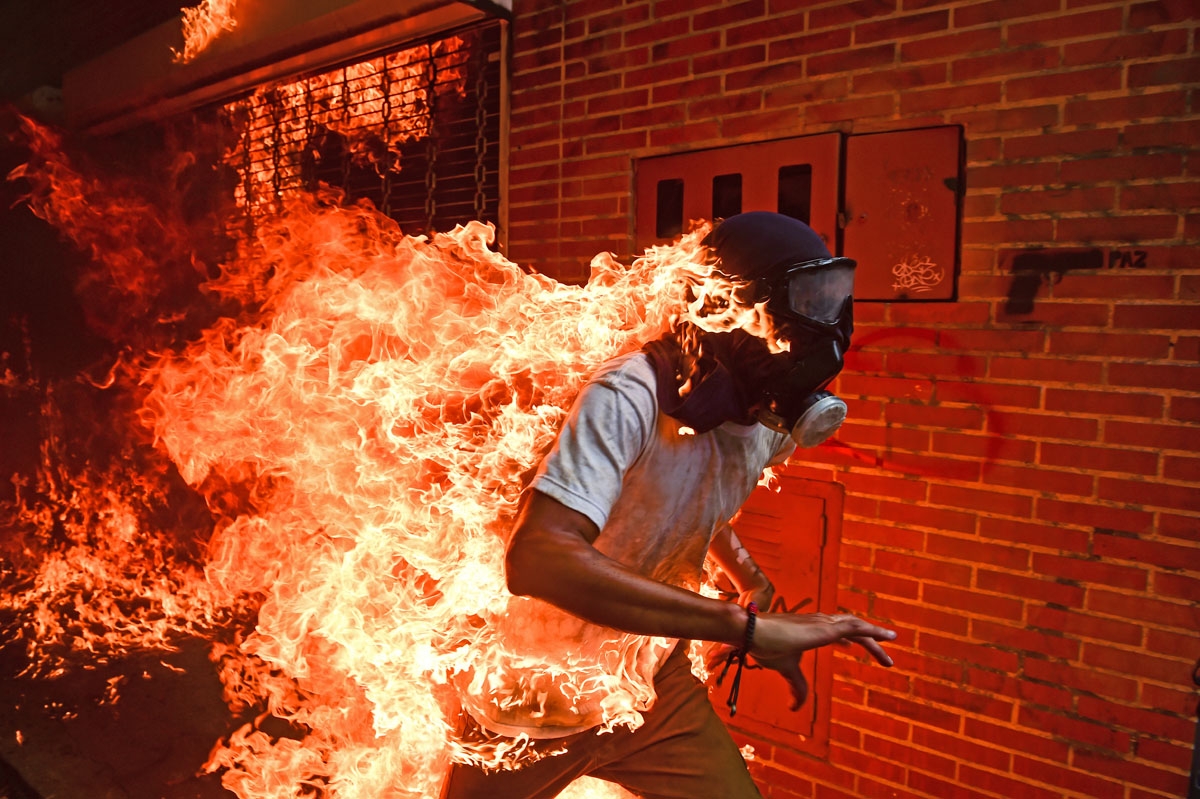 A demonstrator catches fire during clashes with riot police within a protest against Venezuelan President Nicolas Maduro, in Caracas on May 3, 2017. Venezuela's angry opposition rallied Wednesday vowing huge street protests against President Nicolas Madu