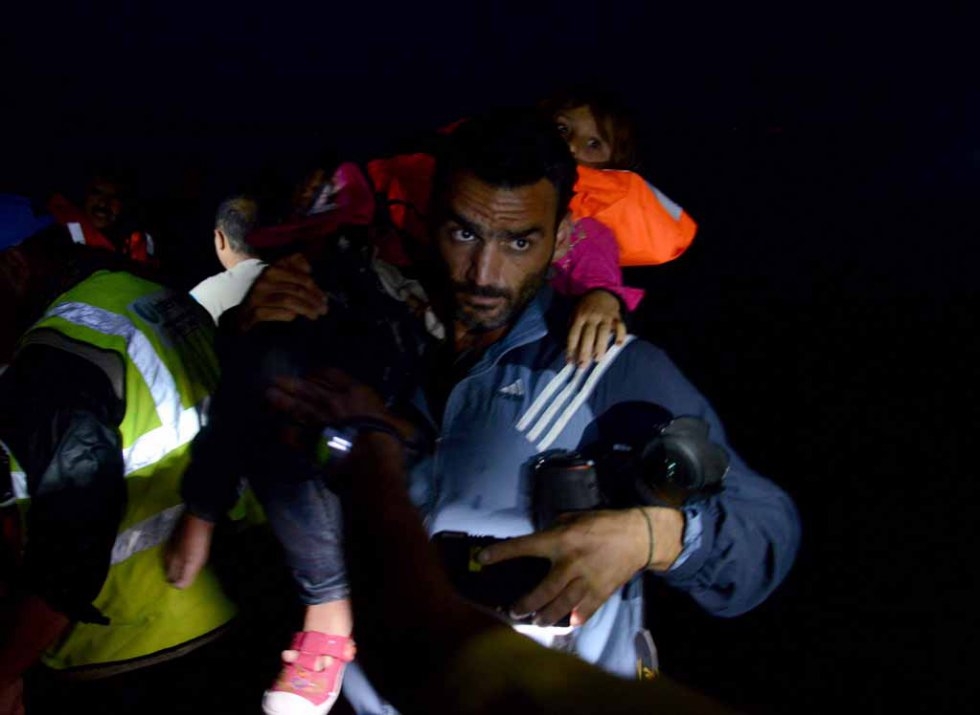 Aris Messinis transporte un enfant sur le rivage, début octobre. Aris Messinis transporte un enfant sur le rivage, début octobre.