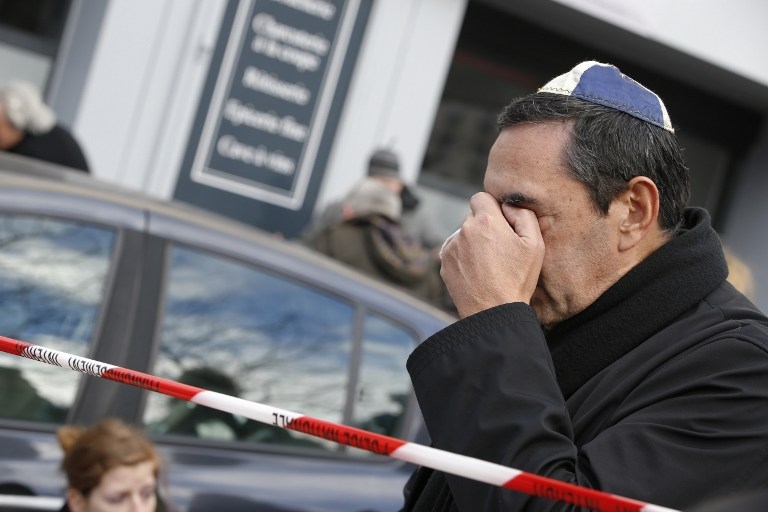 Un homme pleure devant l'épicerie au lendemain de la prise d'otages, le 10 janvier 2015 Un homme pleure devant l'épicerie au lendemain de la prise d'otages, le 10 janvier 2015