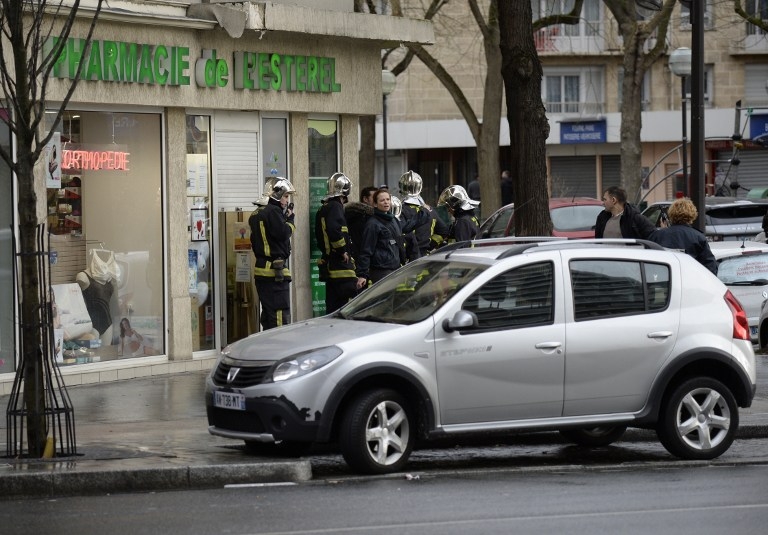 Des pompiers attendent à côté d'une pharmacie près de l'épicerie de la Porte de Vincennes Des pompiers attendent à côté d'une pharmacie près de l'épicerie de la Porte de Vincennes